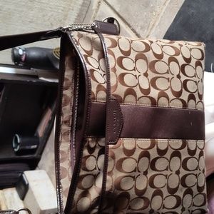 Brown canvas crossbody coach purse.